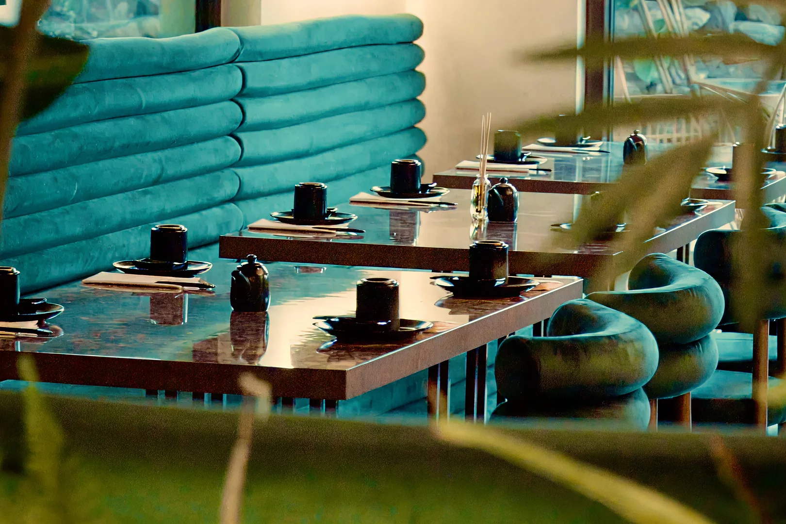 Comedor de restaurante de diseño moderno con asientos aterciopelados en tonos turquesa.