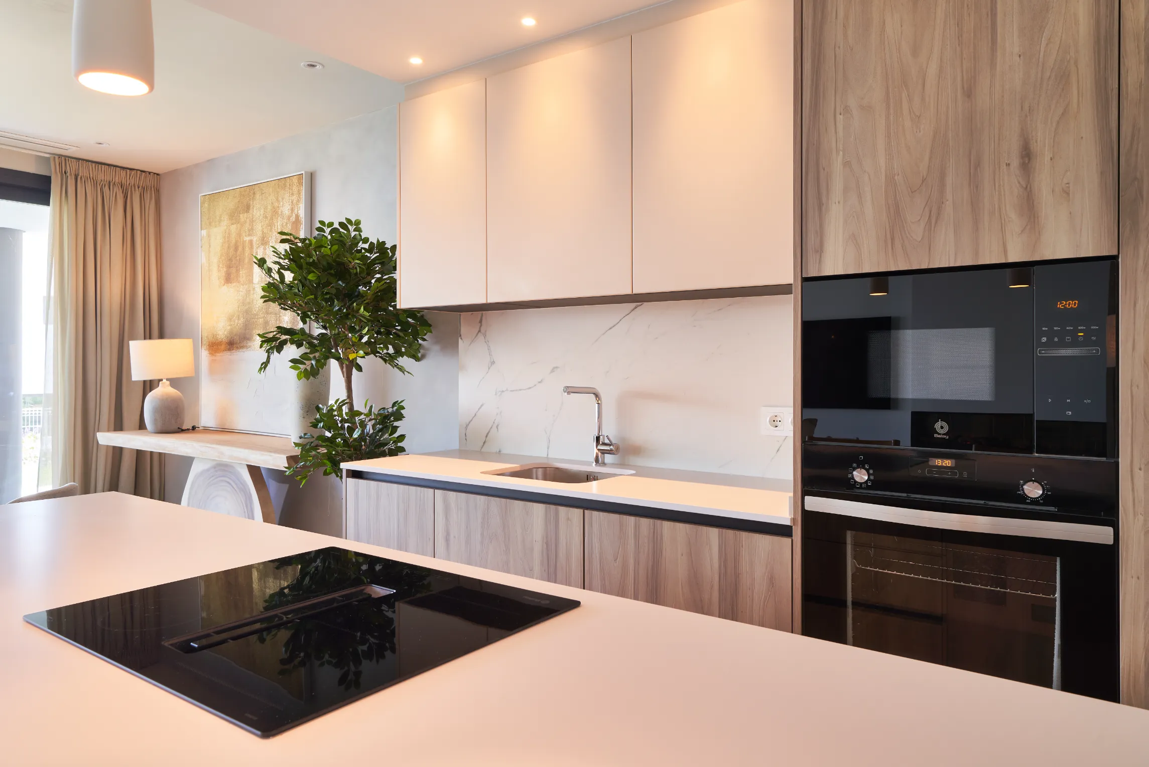 Cocina moderna con isla y electrodomésticos integrados.