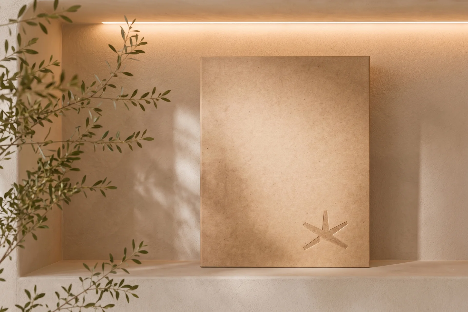 Carpeta corporativa con el logotipo KV grabado en bajorrelieve expuesta en una hornacina iluminada.